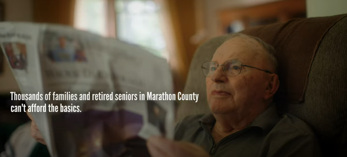 Man on couch reading newspaper