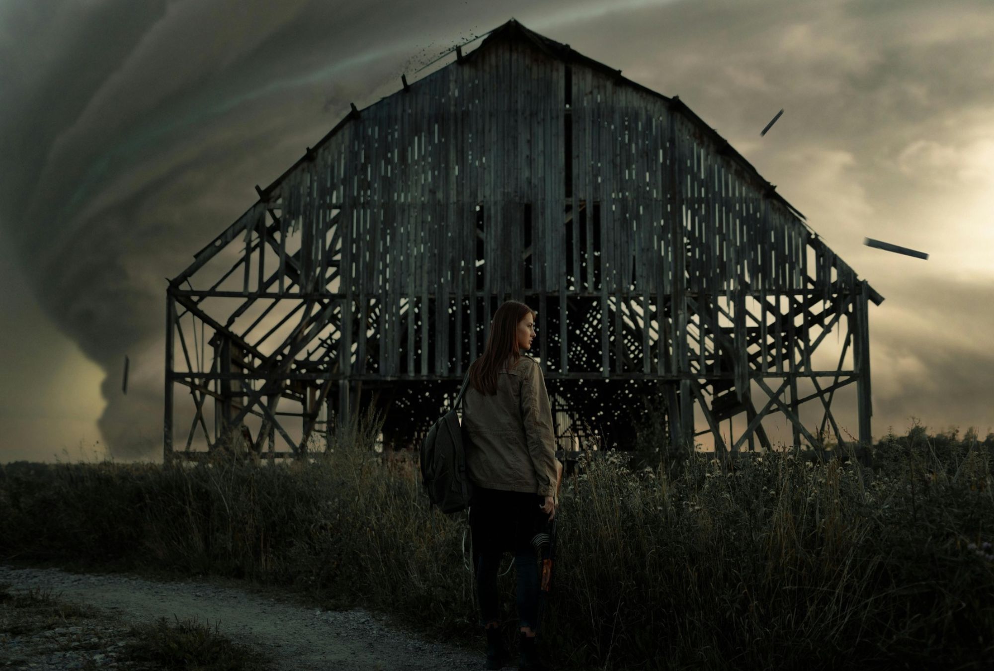 Woman standing in front of a dilapidated barn