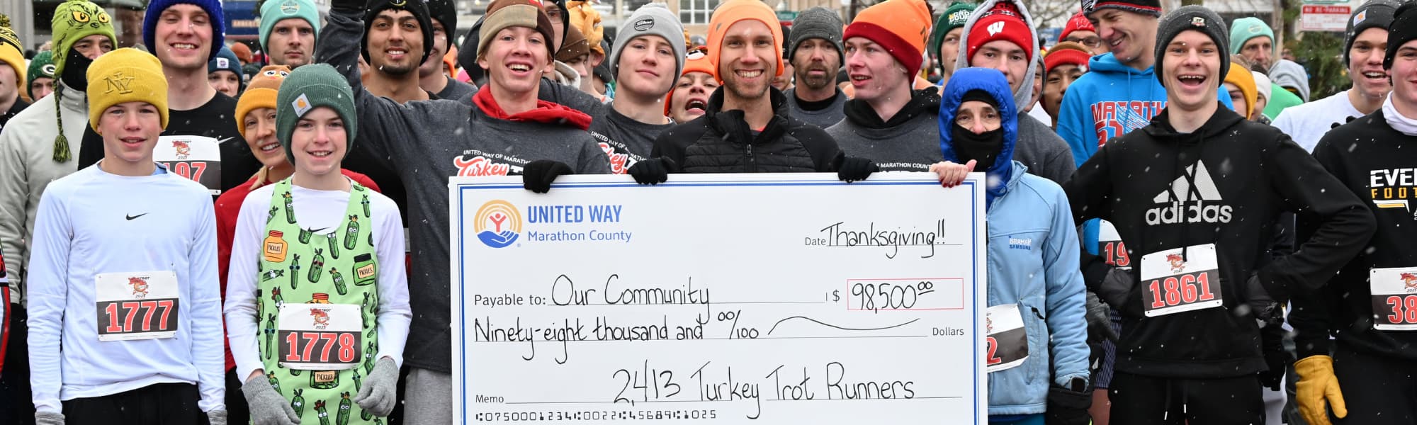 Runners holding a big check