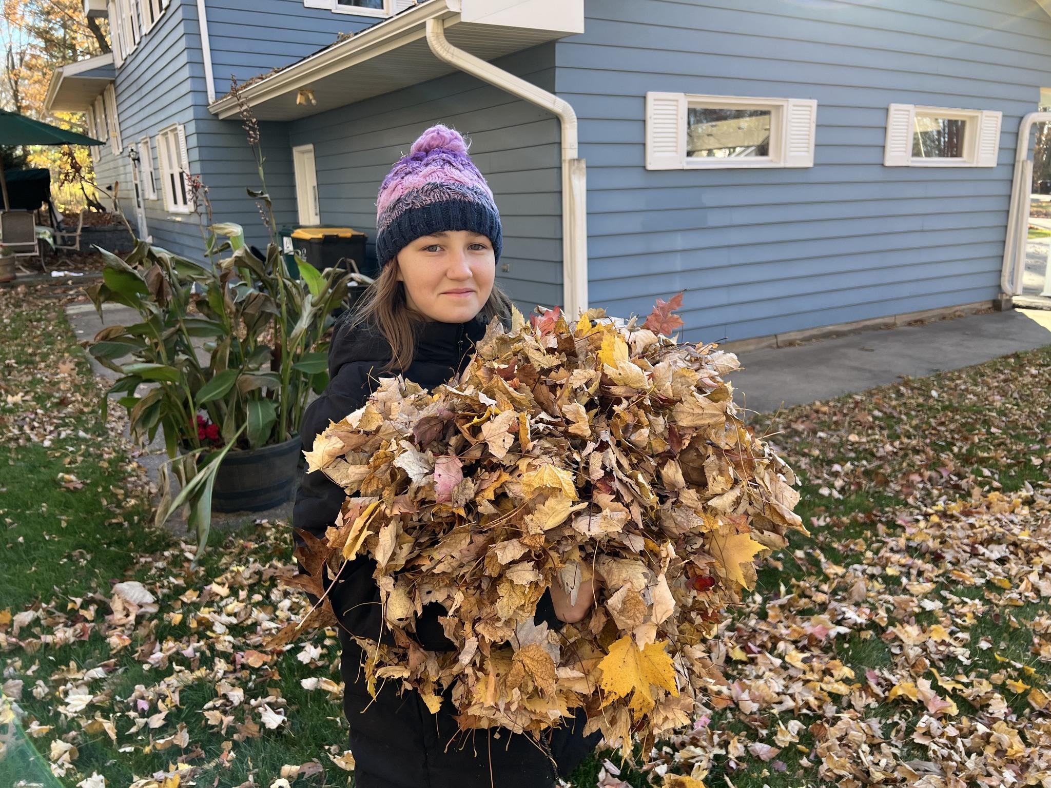 Girl with an armful of leaves
