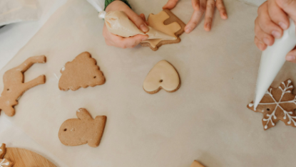 Hands decorating cookies 